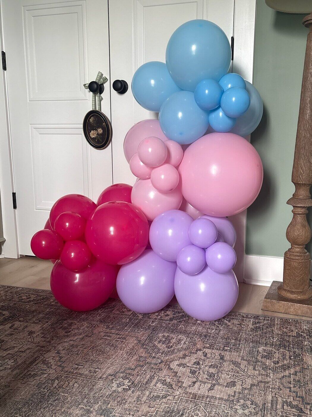 Pink and lilac balloon column beside a doorway
