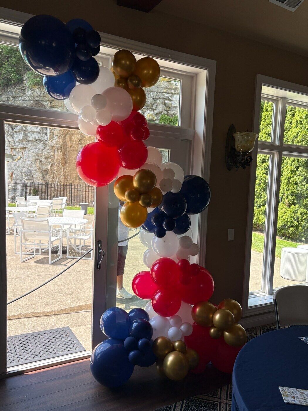 Patriotic navy, red and gold balloon arch in a doorway
