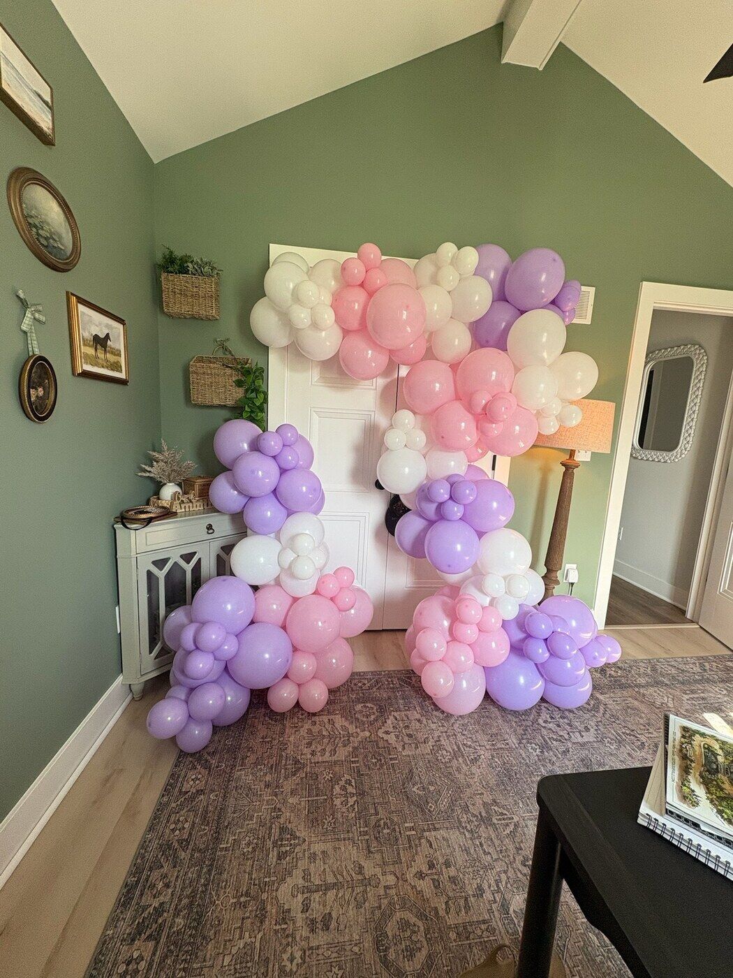 Pink, lilac and white balloon garland in a living room