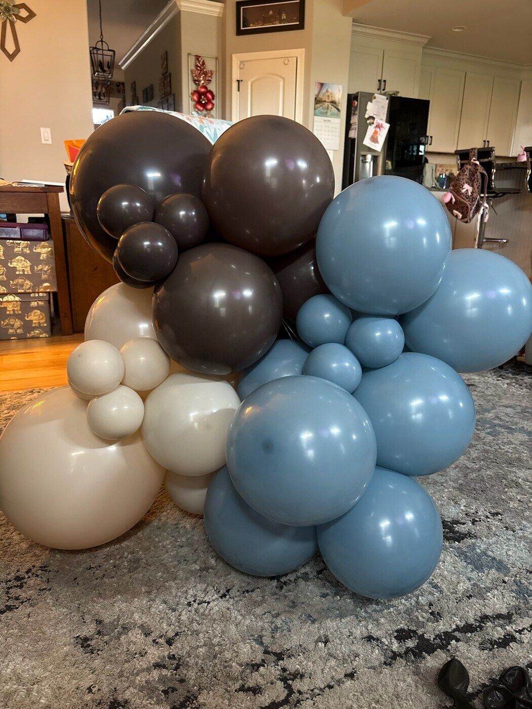 Brown, blue and cream balloon cluster on a kitchen counter