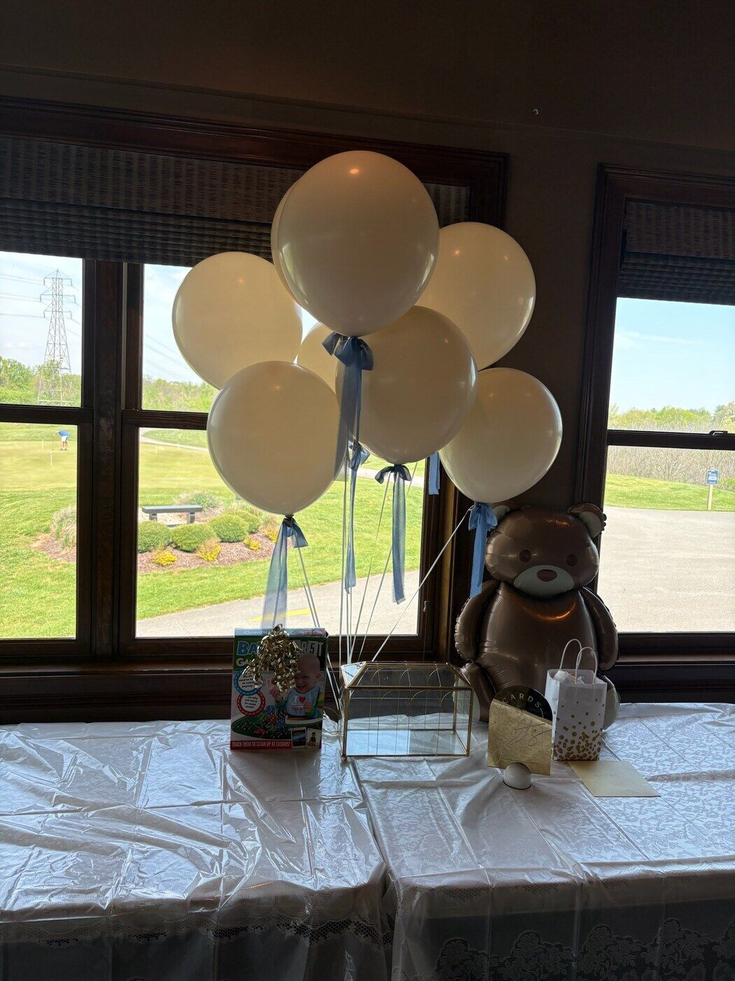 Cream balloon bouquet with a teddy bear for a baby shower